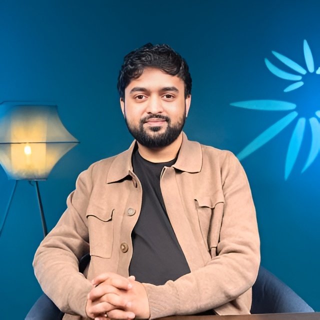 Portrait of Best SEO Specialist in Italy Ibrahim Niloy sitting confidently in a modern office studio setting