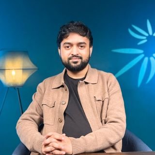 Portrait of Best SEO Specialist in Italy Ibrahim Niloy sitting confidently in a modern office studio setting